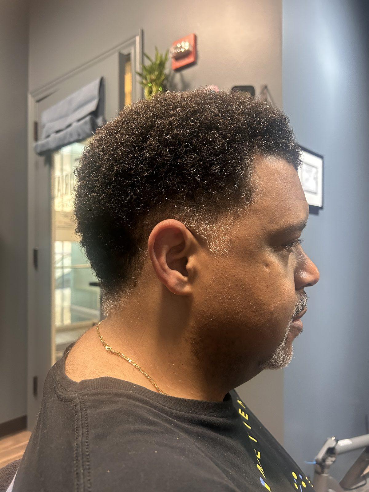 Rounded curly cut with a full, textured beard